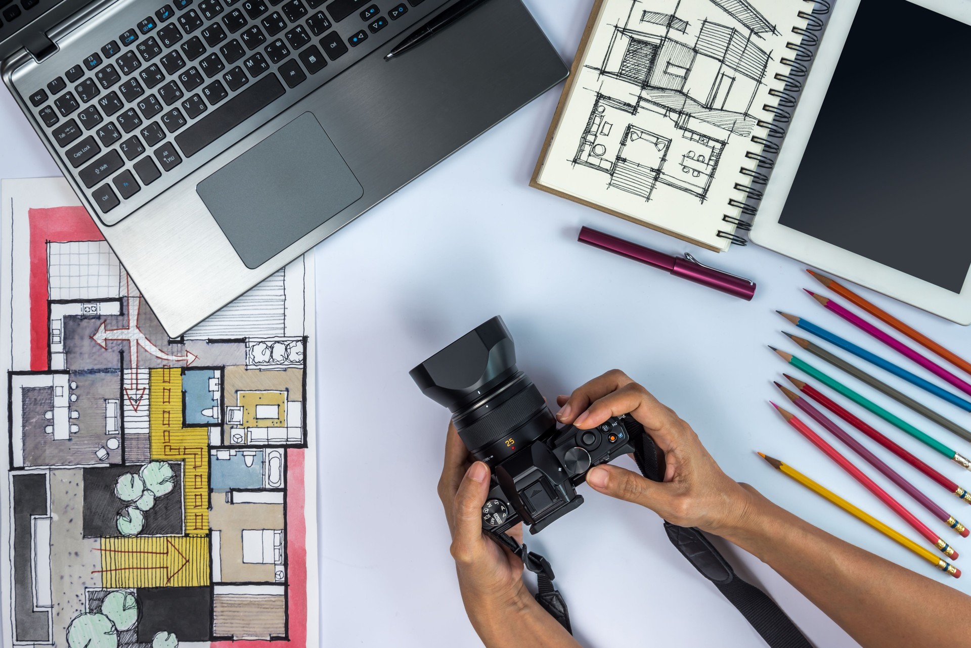 Designer working at office desk with camera, laptop, tablet, illustration
